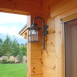 A wrought iron wall lighting in a mountain cottage patio - luxury outdoor lamp