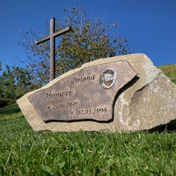 Grabstein mit einem geschmiedeten Kreuz, einer Tafel mit Inschriften und einem Foto sowie einer dekorativen Rose