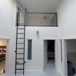 The use of space in high rooms will be ensured by a modern metal railing with a ladder The use of space in high rooms will be ensured by a modern metal railing with a ladder