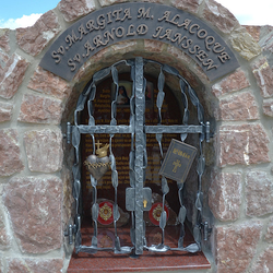 Schmiedeeisernes Denkmal. St. Margareta M. Alacoque – Herz mit Flamme, Kreuz und Dornenkrone, St. Arnold Janssen – Bibel Schmiedeeisernes Denkmal. St. Margareta M. Alacoque – Herz mit Flamme, Kreuz und Dornenkrone, St. Arnold Janssen – Bibel