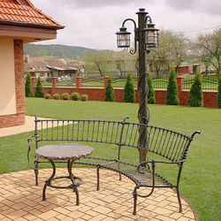 Wrought iron lights and furniture in a garden Wrought iron lights and furniture in a garden