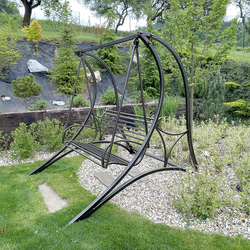 Wrought-iron garden swing in the garden of a family house  forged swing