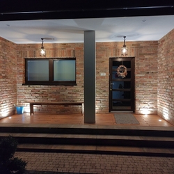 Abendaussicht auf beleuchteten Eintritt ins Einfamilienhaus – geschmiedete Außenleuchten Abendaussicht auf beleuchteten Eintritt ins Einfamilienhaus – geschmiedete Außenleuchten