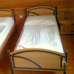 Schmiedeeisernes Bett  Kombination aus Holz und Metall in einer Pension  geschmiedete Mbel