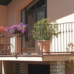 An exterior wrought iron balcony railing