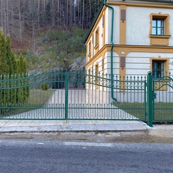 Geschmiedetes Tor mit einer Pforte in grner Farbe und goldener Patina