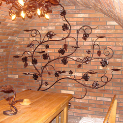 Kerzenleuchter, geschmiedete Weinrebe an der Wand – kunstvoller Kerzenleuchter in einem Weinkeller Kerzenleuchter, geschmiedete Weinrebe an der Wand – kunstvoller Kerzenleuchter in einem Weinkeller