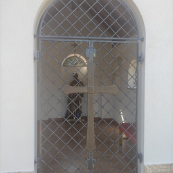 Geschmiedete Gitter mit einem Kreuz an einer Kapelle