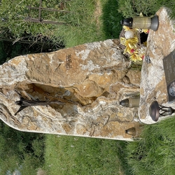 Statue des Auferstandenen Christus und eine Tafel mit Inschriften und einem Foto auf dem Grabstein