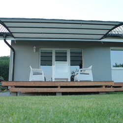 Schmiedeeiserne Überdachung der Terrasse eines Einfamilienhauses im modernen Stil Schmiedeeiserne Überdachung der Terrasse eines Einfamilienhauses im modernen Stil