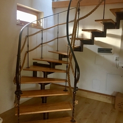 Geschmiedetes Wendeltreppe mit Geländer ergänzt mit Seil im Innenraum eines Einfamilienhauses im Osten der Slowakei Geschmiedetes Wendeltreppe mit Geländer ergänzt mit Seil im Innenraum eines Einfamilienhauses im Osten der Slowakei