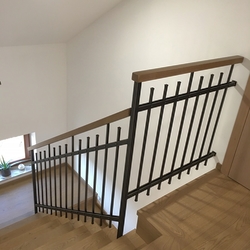 Einfaches Design eines geschmiedeten Innengeländers mit einem hölzernen Handlauf Einfaches Design eines geschmiedeten Innengeländers mit einem hölzernen Handlauf