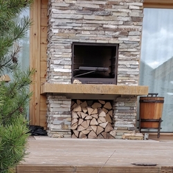 Geschmiedetes Kaminzubehör + Holzkorb mit handgeschmiedeten Kaminaccessoires im Exterieur Geschmiedetes Kaminzubehör + Holzkorb mit handgeschmiedeten Kaminaccessoires im Exterieur